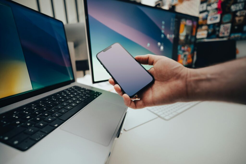 A contemporary workspace with a smartphone and laptop, showcasing modern technology in use.